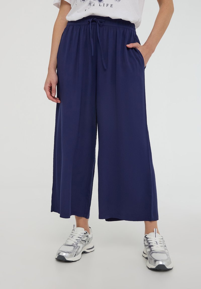 Pantaloni a gamba larga blu navy in tessuto leggero con vita elastica e coulisse, dotati di tasche laterali e vestibilità comoda.
