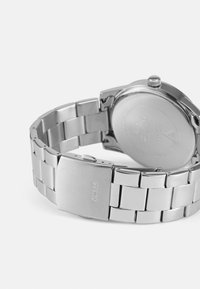 Uhr aus silbernem Edelstahl mit einem glatten Armband und einem runden Gehäuse. Sie hat eine polierte Oberfläche und einen Clipverschluss. Die Rückseite ist graviert.