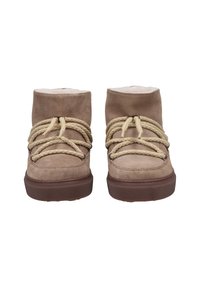 Botas de tobillo de ante marrón con una superficie texturizada, con cordones de cuerda crema y un cuello acolchado, montadas sobre una suela de goma.