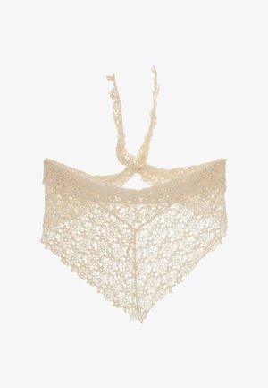 Haut en dentelle crochet couleur crème avec motifs floraux et nœud devant sur fond blanc.
