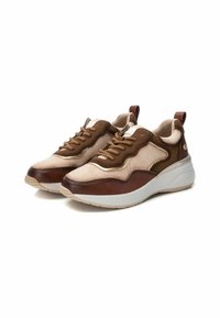 Zapatillas marrones y crema que presentan una mezcla de ante y cuero, forma redondeada, suela gruesa blanca y un cordón prominente en la parte superior.