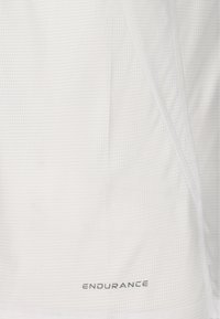 Close-up of white fabric with a subtle grid pattern and “ENDURANCE” printed in small, gray uppercase letters near the bottom edge.