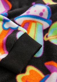 Fleece-Stoff mit schwarzem Hintergrund und bunten Mustern von Herzen und Eiscreme-Waffeln. Der Bündchen ist aus schwarzem, geripptem Material.