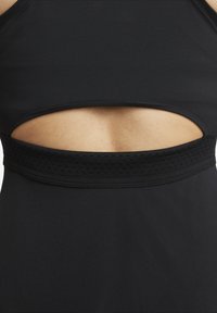 Crni atletski crop top s izrezom i teksturiranim elastičnim pojasom u struku. Glatka tkanina s minimalnim šavovima.