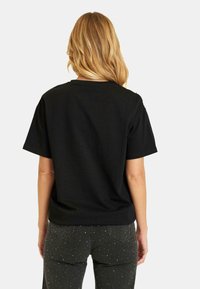 Zwarte katoenen t-shirt met korte mouwen, ronde halslijn en een ontspannen pasvorm. Glad textuur zonder zichtbare patronen of hardware.