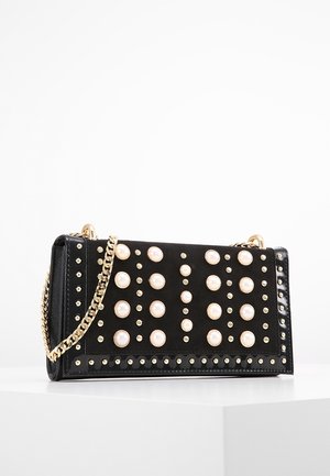 Czarna prostokątna torebka z złotym łańcuszkiem, ozdobiona dużymi perełkowymi ćwiekami oraz małymi okrągłymi ćwiekami w złotym kolorze, ułożonymi w wzór.