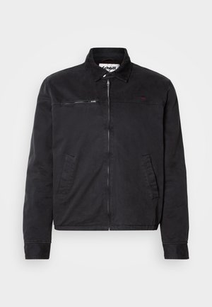 Giacca nera in cotone con zip frontale, colletto in velluto a coste, tasche laterali e una piccola tasca con zip sul petto. Presenta un branding discreto.