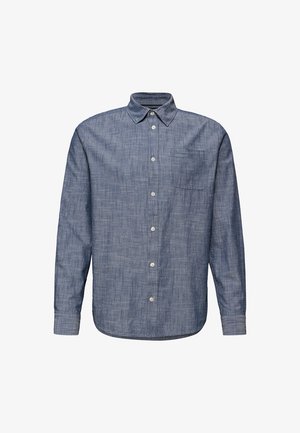 Chemise en chambray bleu à manches longues avec col pointu et une poche poitrine unique, présentée sur un fond blanc.