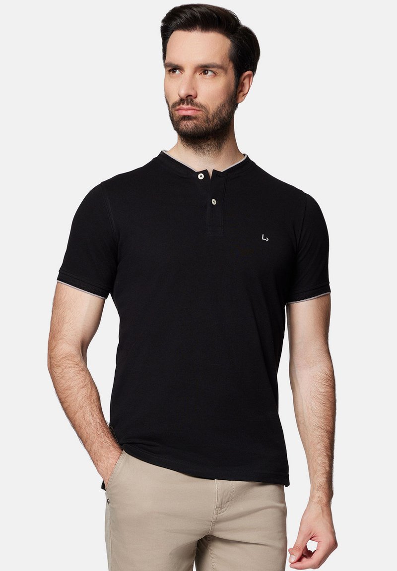 Czarna koszulka polo z krótkimi rękawami, z zapięciem na guziki i subtelnymi kontrastowymi przeszyciami. Materiał wydaje się gładki i dopasowany.