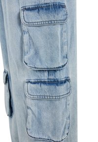 Lyseblå denim cargo bukser med to store påsyede lommer, synlig syning og en let falmet tekstur.