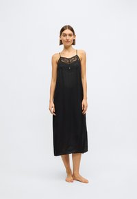 Rochie slip din satin negru cu aplicație de dantelă pe corset, bretele subțiri reglabile și o siluetă fluidă care ajunge până la jumătatea gambei.