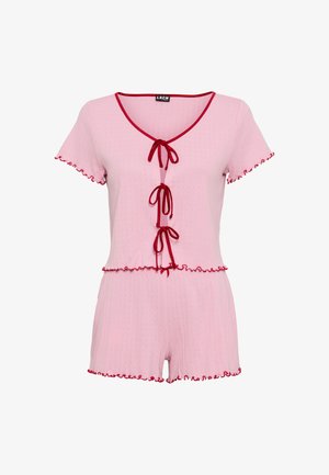Lyserød kort romper med røde flæseakcenter, som har rund halsudskæring og tre bindebånd foran til justering. Fremstillet af tekstureret stof.