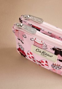 Rožinė raštuota užtrauktuko kišenė su gyvūnų motyvais, turinti du sidabrinius užtrauktukus ir baltą etiketę su užrašu "Cath Kidston London."