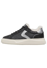 Sneaker nera e argento con tessuto testurizzato, rivestimento in pelliccia e una suola in gomma bianca spessa con design ondulato.