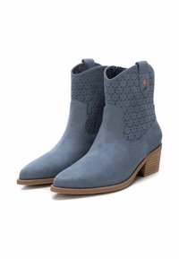 Botas de tobillo de ante azul con diseño perforado y puntera puntiaguda. Tacón apilado marrón y detalles de costura en contraste.
