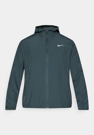 Casaco corta-vento Nike em verde escuro, com fecho frontal completo, capuz ajustável e logótipo branco no peito esquerdo. Tecido leve e suave.