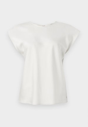 Bluză albă cu mâneci scurte, decolteu rotund și croială lejeră, expusă pe un fundal simplu și deschis la culoare.