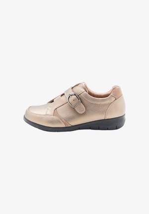 Scarpa in pelle beige con finitura testurizzata, cinturino con fibbia regolabile, punta rotonda e suola in gomma nera, caratterizzata da un design a profilo basso.