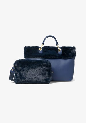 Navy blue handbag with a faux fur top trim, featuring a smooth leather body and gold hardware; includes a matching fur-lined pouch.