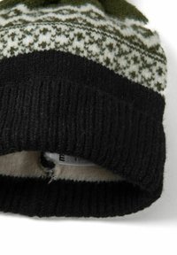 Kötött sapka, zöld és fehér mintás anyaggal a tetején, fekete bordázott mandzsettával és puha béléssel, belül látható címkével.