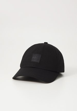 Black baseball cap made of fabric, featuring a rounded crown and a curved brim. Includes a square logo patch on the front.