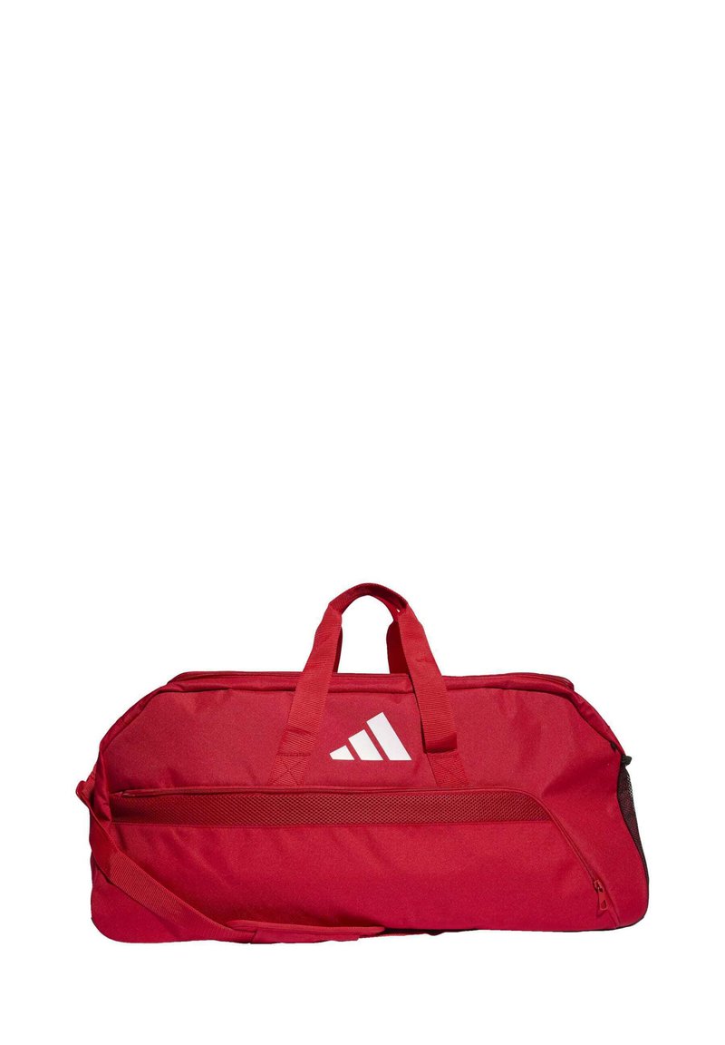Borsa da viaggio rossa in tessuto resistente, con doppie maniglie superiori, una tracolla regolabile e un design con logo bianco a tre righe.