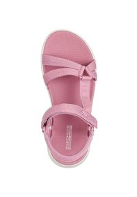 Sandalia rosa con una plantilla texturizada, múltiples correas ajustables y suela blanca. Presenta la marca "SKECHERS GOGA MAT" en la plantilla.