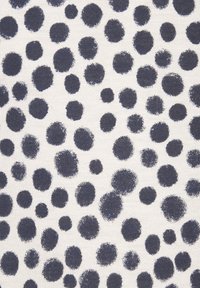 Raksts audums ar krēmkrāsas fonu, kurā redzami dažāda izmēra tumši zilie punkti izkliedētā veidā, demonstrējot tekstūrētu virsmu.