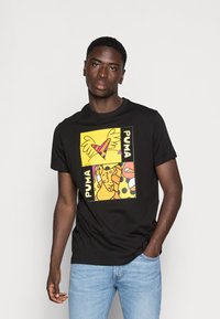 Sort bomulds T-shirt med et farverigt grafisk print i gule og lyserøde nuancer og "PUMA" tekst. Pasform er standard med korte ærmer.