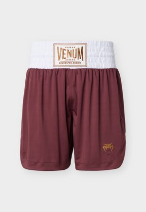 Tubakapunased poksipüksid, millel lai valge elastne vöökoht, kuldse kirjaga "VENUM" silt ja väikese kuldse maduhammaste logoga jala peal.