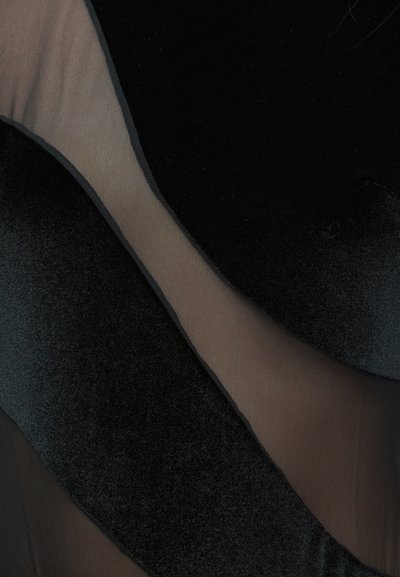 Tecido preto com uma textura de veludo suave em conjunto com seções de malha preta transparente, criando um efeito em camadas com materiais em contraste.