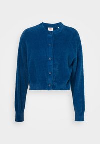 Obcisły kardigan na guziki w miękkim niebieskim futerku. Posiada okrągły dekolt i długie rękawy z prążkowanymi mankietami oraz gładką fakturą.