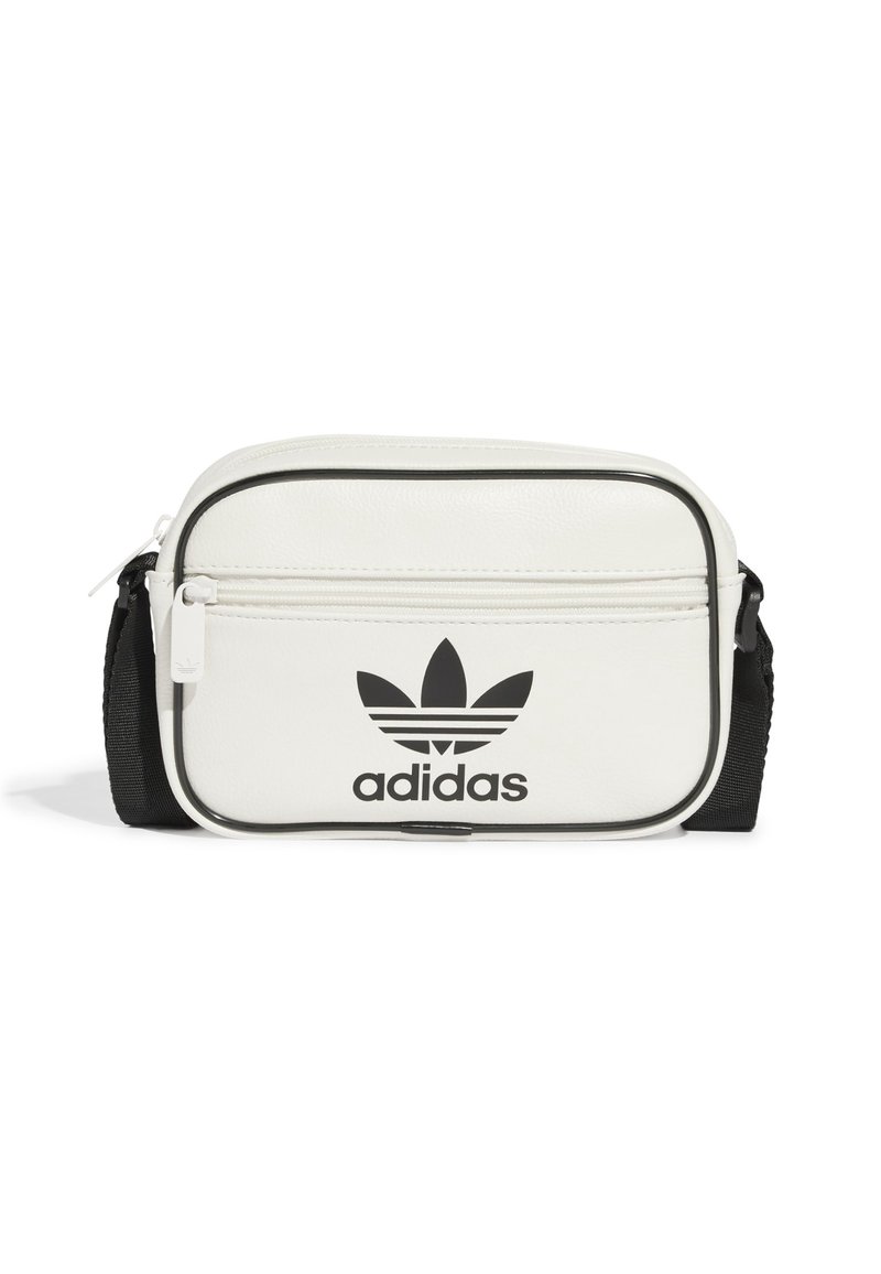 Borsa a tracolla sintetica bianca con zip nera, tracolla nera e logo Adidas nero in evidenza sulla parte anteriore. Forma piccola e rettangolare.