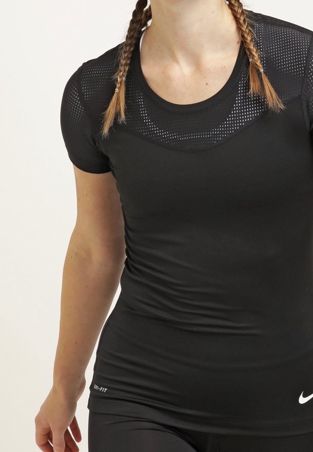 Camiseta deportiva negra de manga corta, hecha de tejido transpirable. Presenta paneles de malla en los hombros y un logo blanco en la parte inferior.