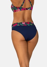 Góra bikini w ciemnoniebieskim kolorze z kwiatowym wzorem i wielokolorową kwiatową opaską. Figi o wysokim kroju w kolorze granatowym. Gładka faktura materiału.