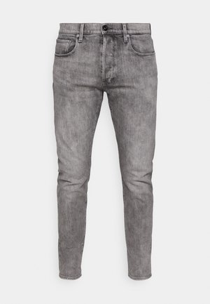 Grå denim jeans med slim fit, der har forlommer, metalknaplukning og diskret falmning i hele stoffet.