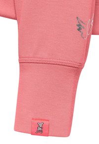 Koralowa różowa bluza z długim rękawem o dopasowanym kroju, miękkiej teksturze oraz srebrnym znaku psa na mankiecie z ozdobnym przeszyciem.