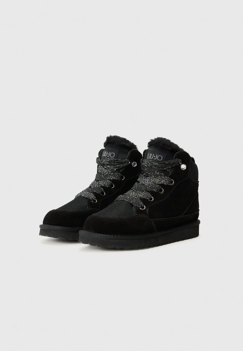 Bottes montantes noires en daim et en maille, avec un col en fausse fourrure, des œillets métalliques et des lacetstexturés et scintillants.