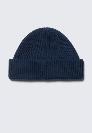 Mørkeblå strikket uldbeanie med en foldet manchet, vist fladt på en lys grå baggrund.