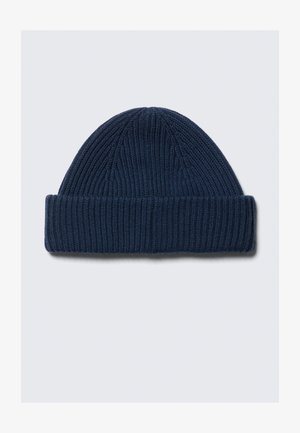 Bonnet en laine tricotée bleu foncé avec un revers, présenté à plat sur un fond gris clair.