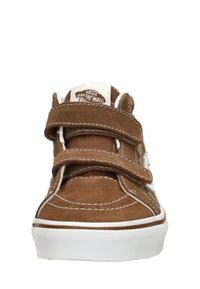 Bruine suède sneakers met twee klittenbandsluitingen, witte rubberen zool en contrasterende stiksels. Logo-opdruk op de tong. Ronde teenvorm.