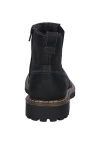 Schwarze Wildleder-Ankle-Boots mit einer strukturierten Oberseite, gepolstertem Kragen und Zickzack-Stichen. Verfügt über eine robuste Gummisohle mit tiefen Profilen.