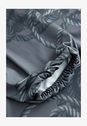 Sivá tkanina s motívom lana, hladkým povrchom a nariasenými okrajmi, zdôrazňujúca jej mäkký, elastický materiál.