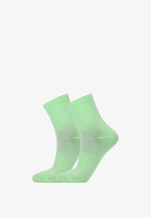 Paire de chaussettes de sport vert clair avec talon et pointe renforcés sur fond blanc.