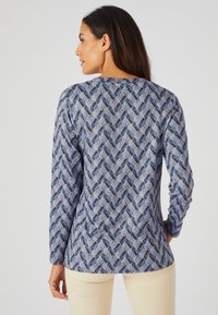 Langarmshirt in blauw met een geometrisch patroon van overlappende vormen. Zacht materiaal met een licht aansluitend ontwerp.