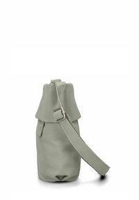 Bolso de piel verde con tapa plegable, correa ajustable y superficie texturizada. Base circular con un diseño de fondo abierto.
