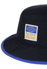 Čierny kyblový klobúk s modrým okrajom a štítkom so svetovým dizajnom, textom "No.94" a logom "DC SHOES" v kontrastných farbách.
