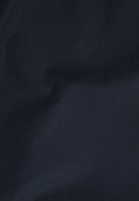 Marineblaue Stoff mit glatter Textur, der einen leichten Glanz und ein minimales Muster aufweist, geeignet für verschiedene Anwendungen wie Polstermöbel oder Bekleidung.