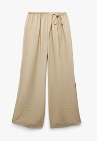 Beige vida byxor med elastisk midja och knytdetalj, med en avslappnad passform och texturerad tyg.