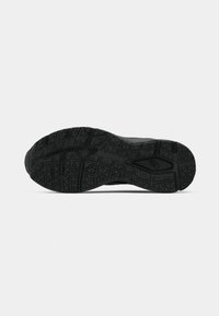 Semelle de chaussure de sport noire avec un motif de crampons pour l'adhérence, en matériau en caoutchouc avec des éléments de design texturés, et un bout arrondi.